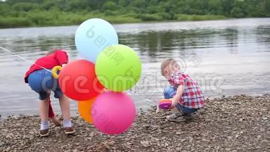 两个孩子在河岸上玩耍。 <strong>扔石头</strong>，泼水。 美丽的夏日风景。